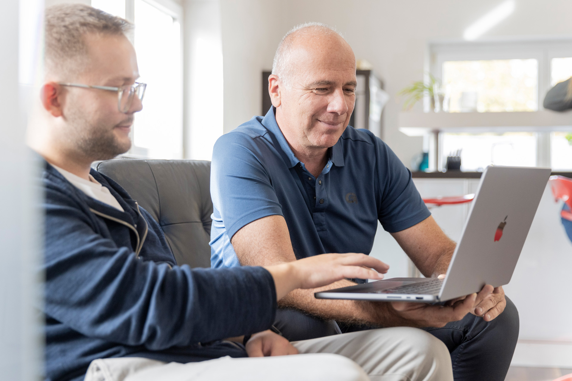 Zwei Männer arbeiten an einem Apple MacBook