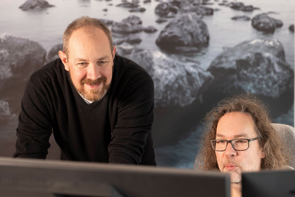 Zwei Männer schauen auf einen Monitor